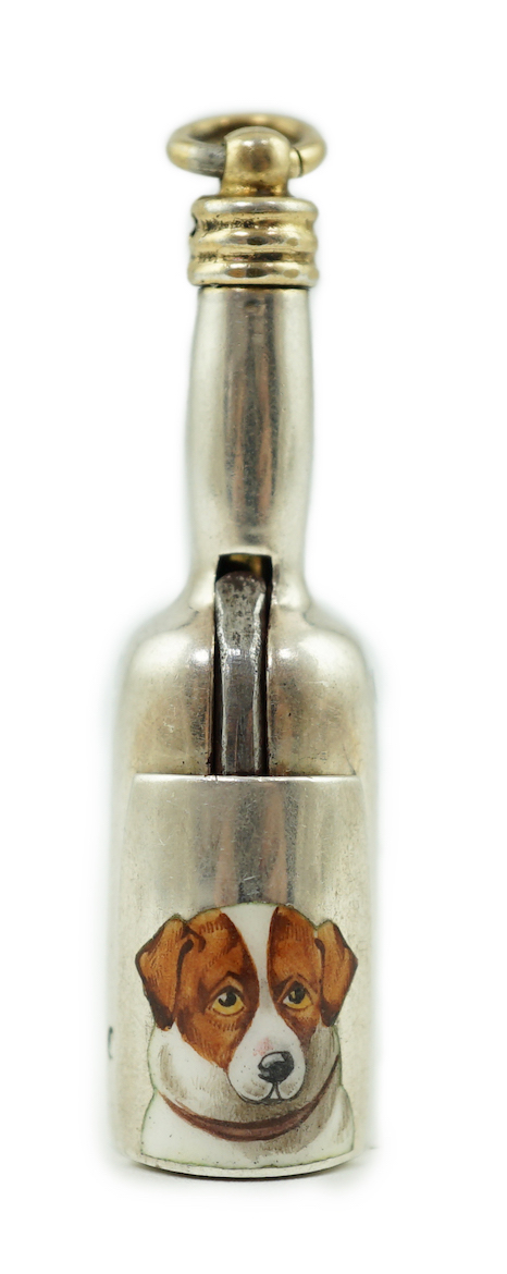 A late Victorian novelty parcel gilt silver cigar cutter, modelled as a bottle, the hinged section enamelled with a head of a dog